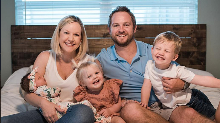 A mom and dad holding three kids