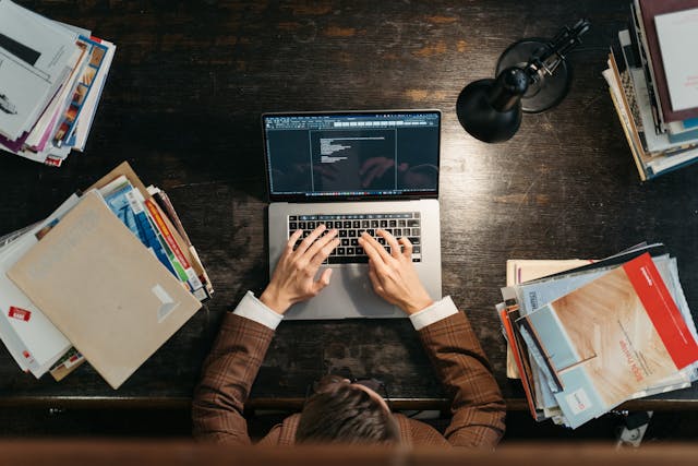 Someone working on a cluttered desk